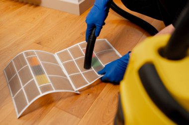 Bir dairede bir temizleyici banyonun yüzeyini toz fırçasıyla temizler.