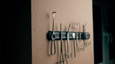 Duvardaki bir veteriner kliniğine yakın plan. Çeşitli cerrahi aletlerin manyetik paneli.