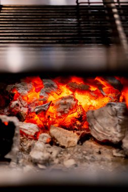 Japon restoranının kompakt masa üstü ızgarasında yüksek sıcaklıktaki kömürleri pişirmek için yakın plan.