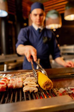 Japon restoranına yakın çekim yapan şef, balık için meze olarak çeşitli sebzeler pişirir.