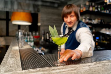 Bir Japon restoranında barmen tezgahın üzerinde hazır kokteyl ikram eder.