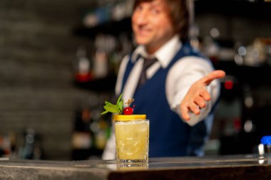 Barın arkasındaki bir Japon restoranında hazır sarı egzotik kokteyli olan bir barmen.