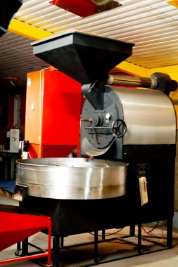 Küçük bir kahve kızartma fabrikasında bir makine özel üretim kahve kızartıyor.