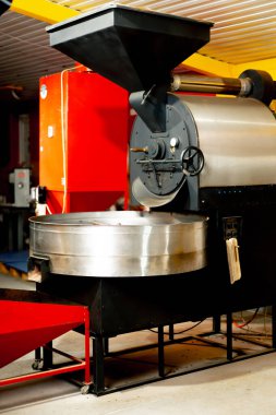 Küçük bir kahve kızartma fabrikasında bir makine özel üretim kahve kızartıyor.