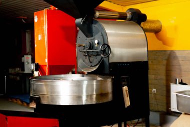 Küçük bir kahve kızartma fabrikasında bir makine özel üretim kahve kızartıyor.