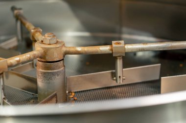 Boş bir demir kahve varilinin yakın plan çekimi kahve kızartma fabrikasında duruyor.