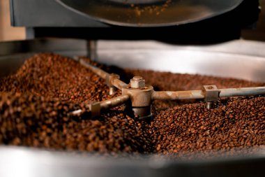 Bir kahve kızartma fabrikasının yakın plan çekimi davulun içinde kavurucu bir kahve
