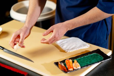 Japon restoranına yakın çekim yapan şef, tabağa çiğ balık parçaları serer.