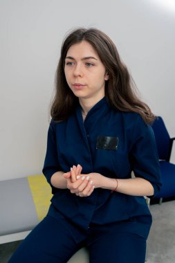 Klinikte yakın plan mavi kulaklı genç bir doktor konsültasyon yapıyor.