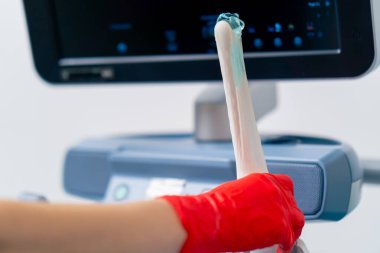 Kliniğin jinekoloji ofisini kapatın. Doktor ultrason makinesini hazır tutuyor.