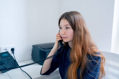 Jinekoloji muayenehanesinde mavi üniformalı bir doktor hasta için randevu alır.