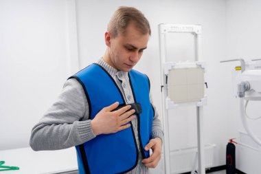 Özel bir klinikte, beyaz bir röntgen odasındaki hasta bir prosedüre hazırlanır.