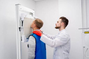 Özel bir klinikte, beyaz bir röntgen odasındaki hasta bir prosedüre hazırlanır.