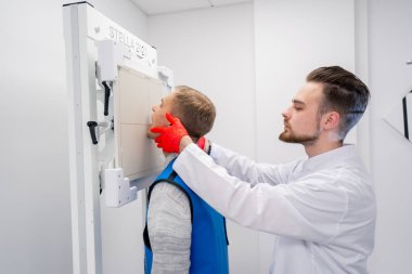 Özel bir klinikte, beyaz bir röntgen odasındaki hasta bir prosedüre hazırlanır.
