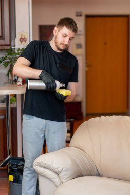 Bir apartman dairesinde profesyonel temizlik. Temizlikçi, cilalama maddesini bir beze uygular.