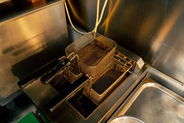 Profesyonel bir mutfakta en iyi çekim. Masada çift fritöz var. Patates kızartması seti.
