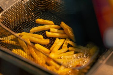 Profesyonel bir mutfakta kızartma kızartılıyor. Kızartma makinesinde.