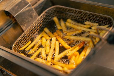 Profesyonel bir mutfakta kızartma kızartılıyor. Kızartma makinesinde.