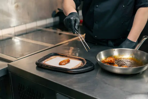 Şef Profesyonel Bir Mutfakta Ahşap Bir Tepsiye Hazır Tavuk Kanadı — Stok fotoğraf