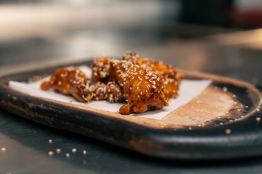 Profesyonel mutfakta, ahşap tepside hazır tavuk kanadı.