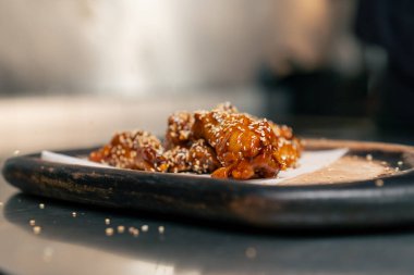 Profesyonel mutfakta, ahşap tepside hazır tavuk kanadı.