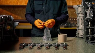 Masanın üstündeki benzin istasyonunda genç bir tamirci piston için yeni bir parça yazdırıyor.