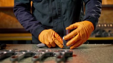 Masadaki bir benzin istasyonunda genç bir motor tamircisi yeni bir piston parçası monte ediyor.