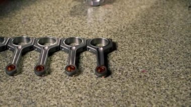 Bir benzin istasyonunda üstadın elleri masanın üzerinde yatan piston parçalarından birini alır.