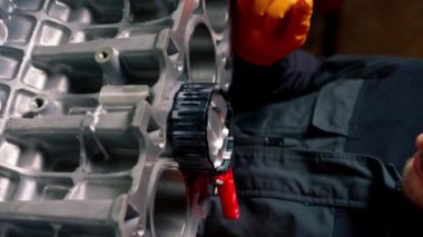 dikey video bir servis istasyonunda masanın üzerinde genç bir motor tamircisi bir piston parçası yerleştirir