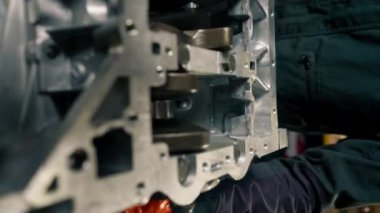 dikey video masadaki bir servis istasyonunda motor tamircisi manuel olarak motordaki krank milini çalıştırır