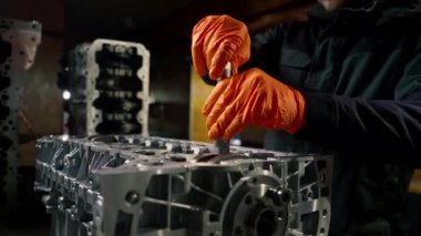 Kilitleri sıkılaştırmak için ana bir cihazın elindeki bir benzin istasyonunda motordaki cıvatalarla çalışır.