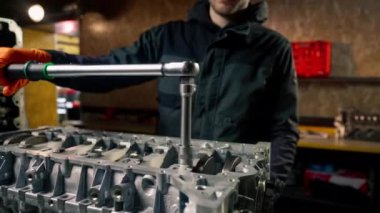 Cıvataları sıkmak için ana bir cihazın elindeki bir benzin istasyonunda motor vidaları ile çalışır.