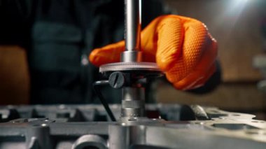 Ustanın elindeki bir benzin istasyonunda cıvataları cıvatalarla sıkan bir cihaz var.