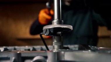 Ustanın elindeki bir benzin istasyonunda cıvataları cıvatalarla sıkan bir cihaz var.