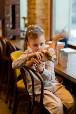 Bir kitapçıda yakın plan güzel bir kız ve oğlan tahta oyuncaklarla oynuyor.