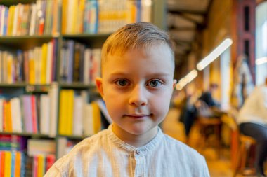 Kitapçıya yakın çekim yapan yakışıklı bir çocuk mutlu müşteriler arasında gülümsüyor.