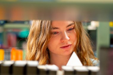 Bir kitapçıya kapandığında genç bir kız sınavlara hazırlanmak için kendine yeni bir kitap seçer.