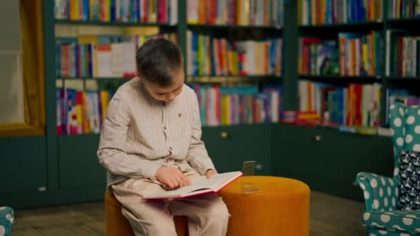 Bookstore Children Area Handsome Little Boy Light Clothes Reads Book — Vídeo de stock