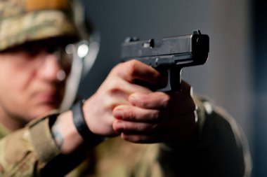 Profesyonel bir atış talimine yakın cephaneli askeri eğitimci silahla nişan alır.