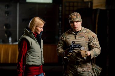 Profesyonel bir atış poligonunda bir askeri eğitmen bir kıza NATO silahlarını nasıl kullanacağını söyler.