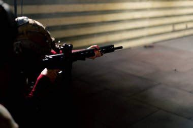 Profesyonel bir atış poligonunda taktik cephaneli ucuz bir kız ateş ediyor.