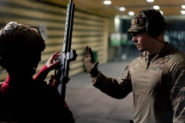 Profesyonel bir atış poligonunda bir askeri eğitmen, ucuz bir kıza NATO tüfeğini nasıl düzgün tutacağını öğretir.
