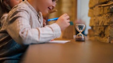 Kitapçıda yakın plan. Masada oturan yakışıklı bir çocuk matematik denklemlerini çözüyor.