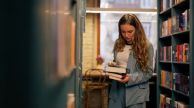 Bir kitapçıda genç bir kız sınavlara hazırlanmak için kendine yeni bir kitap seçer.