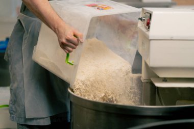 Un karıştırma makinesine dökülürken, profesyonel bir mutfağa yakın çekim yapın.