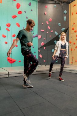 Kaya tırmanışı eğitiminden önce antrenörüyle tırmanan genç bir kız.