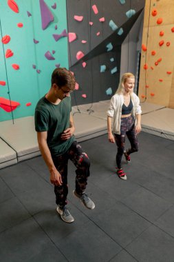 Kaya tırmanışı eğitiminden önce antrenörüyle tırmanan genç bir kız.