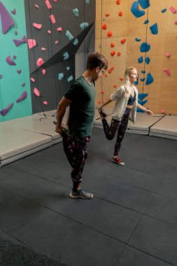 Kaya tırmanışı eğitiminden önce antrenörüyle tırmanan genç bir kız.