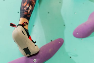 Tırmanma duvarına tırmanan bir kızın bacakları duvara tırmanır.