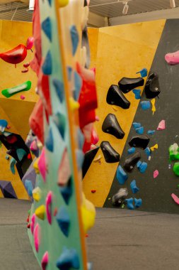 Farklı duvar renklerini eğitmek ve eğitmek için profesyonel bir tırmanışçıyı kapatın.